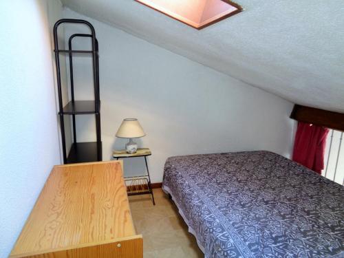 a small bedroom with a bed and a lamp at Studio Mezzanine, Residence avec piscine in Sète