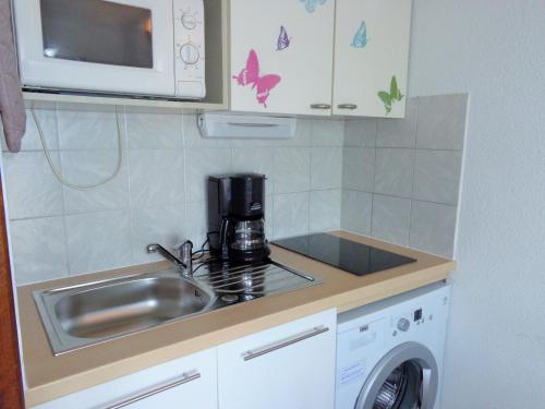 une petite cuisine avec un évier et un micro-ondes dans l'établissement Studio Mezzanine, Residence avec piscine, à Sète