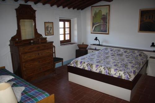 een slaapkamer met een bed, een dressoir en een spiegel bij Agriturismo Podere Somigli di Lorenzo Correani in Greve in Chianti