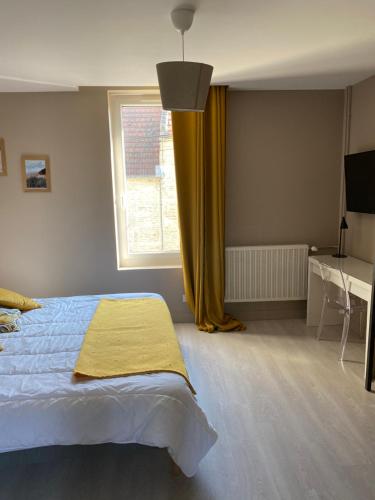 a bedroom with a bed and a window and a desk at Au Rythme des Vagues in Saint-Aubin-sur-Mer