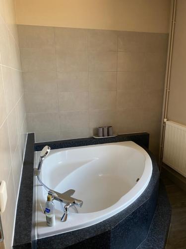 a bath tub in a bathroom with a sink at Au Rythme des Vagues in Saint-Aubin-sur-Mer