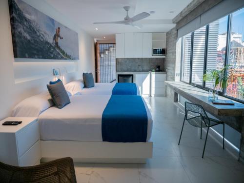 a bedroom with a large bed and a kitchen at Nereidas Lofts in Bucerías