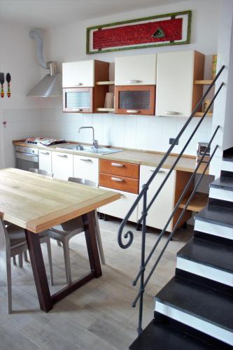 a kitchen with a wooden table and a staircase at Azalea in Recco