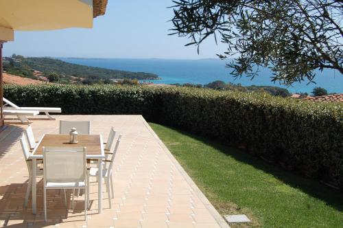 a patio with a table and chairs and the ocean at Le Ville Le Saline in Palau