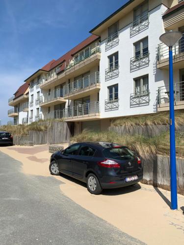 um carro preto estacionado em frente a um edifício em Two bedroom apartment - 50 meters from beach and KYC em Koksijde