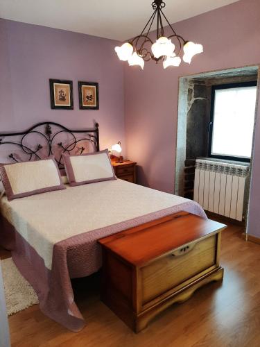 a bedroom with a large bed and a window at Casa Galipendre in A Estrada