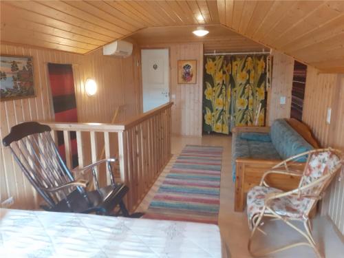 ein Wohnzimmer mit einem Sofa und einem Stuhl in der Unterkunft Karvisen Kissanpäivät Joensuun lähellä in Ruokola