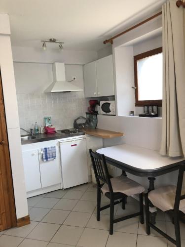 une petite cuisine avec une table et des chaises. dans l'établissement LE PETIT ZEN, à Froberville