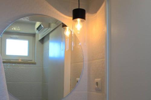 ein Bad mit einem Spiegel, einem Fenster und einem Waschbecken in der Unterkunft Recanto Tia São Magalhães in Ponte da Barca