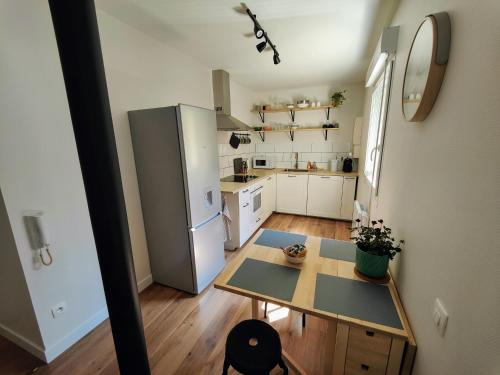 a small kitchen with a table and a refrigerator at Le Bienvenu - T2 avec terrasse au coeur de Malo in Dunkerque