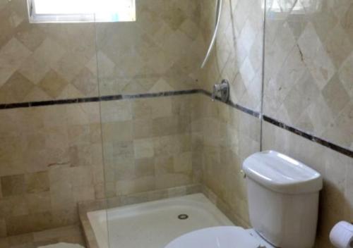 uma casa de banho com um WC, uma banheira e um lavatório. em BAVARO PUNTA CANA Apartamento con Piscina em Punta Cana