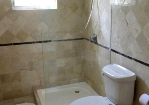 a bathroom with a toilet and a tub and a sink at Apartamento Vacacional con Piscina para Familias en Punta Cana in Punta Cana