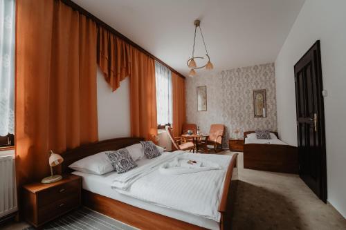 een slaapkamer met een groot bed en een tafel bij Hotel U Lípy in Hřensko