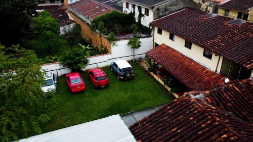 two cars parked in a yard next to a house at Hotel Cacique Chalalá in Charalá