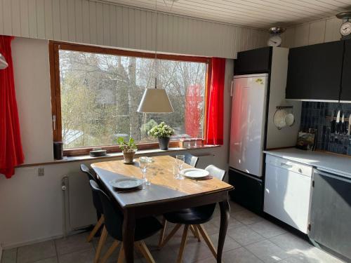 a kitchen with a table with chairs and a window at Retro bolig - fyldt med hygge! Ingen luksus in Kolind