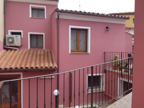 a pink apartment building with a balcony at B&B La Genuina in Guspini