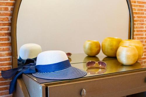 a hat and sunglasses on a dresser with apples at Kastro Apartments in Panormos Rethymno