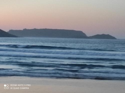 a view of the ocean with mountains in the distance at Malpica Nordic Home in Malpica