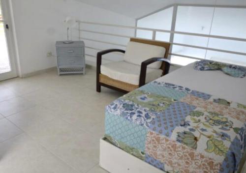 a bedroom with a bed and a chair at Bavaro Punta Cana Apartamento con Piscina in Punta Cana