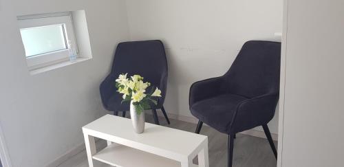 two chairs and a table with a vase of flowers at Studio Anastasia in Limassol