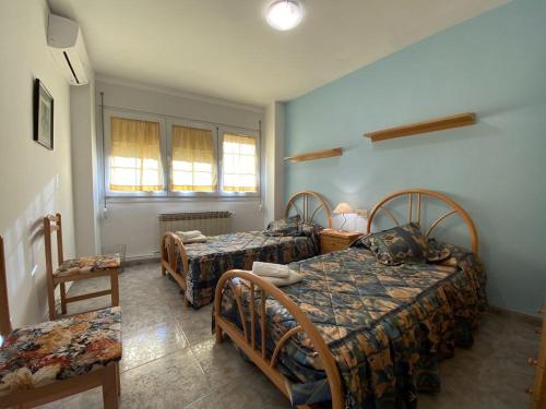 CastelserásにあるCasa La Royaのベッドルーム1室(ベッド2台、椅子、窓付)