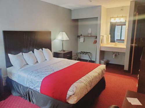 a hotel room with a large bed with a red blanket at Blackstone Lodge and Suites in Lead