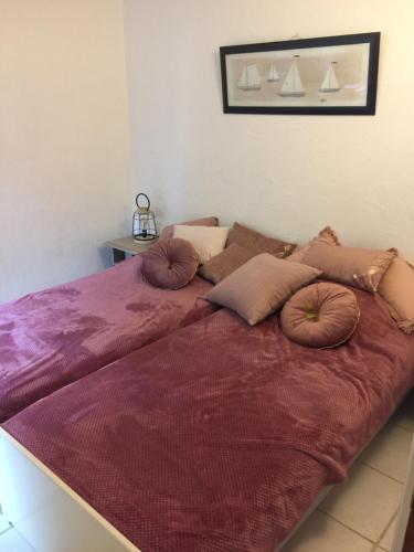 a large bed with pillows on top of it at Favone Mini Villa Playa del Oro in Favone