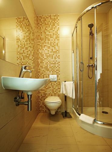 a bathroom with a sink and a toilet and a shower at LIDO Apartamenty in Sarbinowo