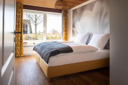 a bedroom with a large bed with a window at Elli´s Hus in Loit