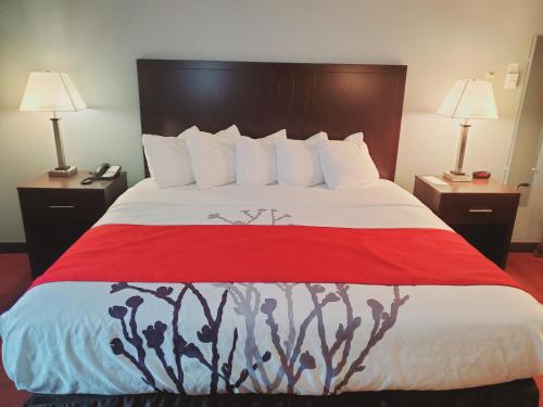 a bedroom with a large bed with a red blanket at Blackstone Lodge and Suites in Lead