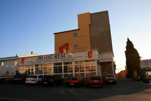 a large building with a neon sign on top of it at Hostal Real in Plasencia