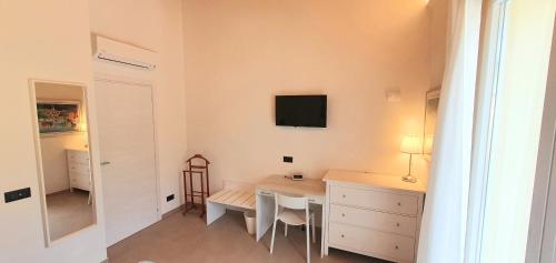 a room with a table and a tv on the wall at Affittacamere La Fonte in Levanto