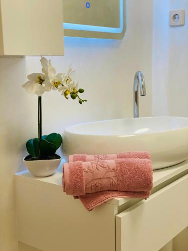 a bathroom with a sink and a pink towel at Apartment Mare in Rab