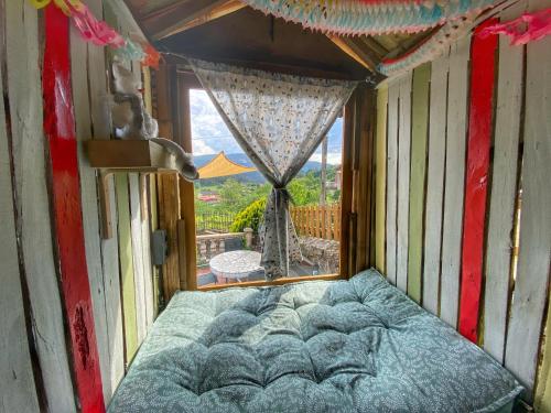 a bed in a room with a large window at Casa Lagar de Arume in Ponteareas