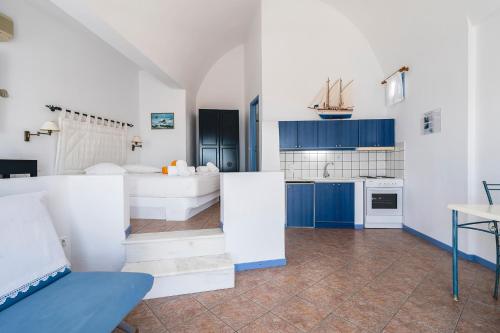 a large kitchen with blue cabinets and white appliances at Apollon Village Hotel in Anafi
