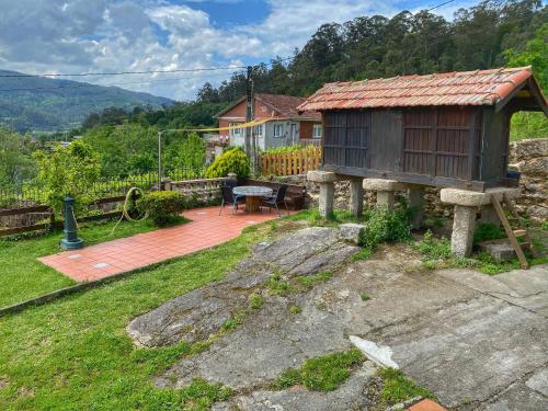 a small house with a table and a patio at Casa Lagar de Arume in Ponteareas