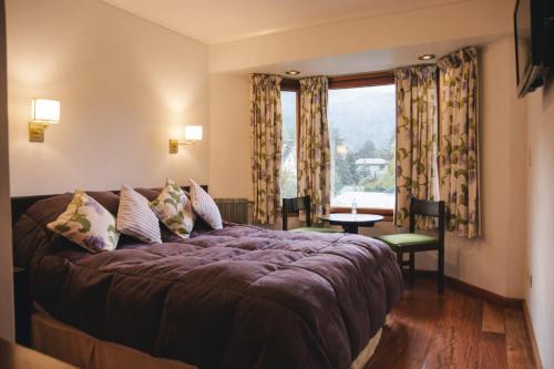 a bedroom with a large bed and a window at Hosteria Las Lengas by Visionnaire in San Martín de los Andes