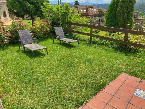 two chairs sitting in the grass in a yard at Casa Lagar de Arume in Ponteareas