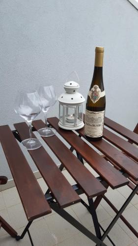 Una botella de vino sentada en una mesa de picnic con copas en SUN & SAND GUESTHOUSE, en Esposende