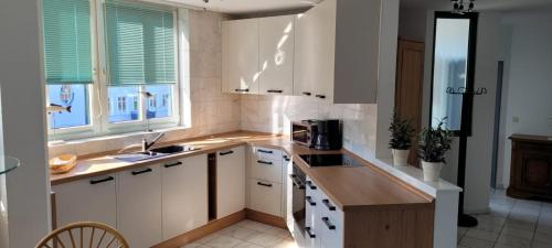 Una cocina con gabinetes blancos y encimera. en Marina 68/70, en Cuxhaven