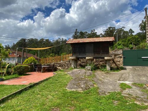 a small house with a table and a yellow tent at Casa Lagar de Arume in Ponteareas
