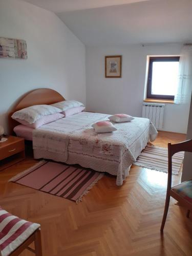 a bedroom with two beds and a wooden floor at APARTMANI SENKA - VILLA OLIVER in Martinšćica