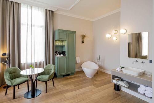 a bathroom with a sink and a table and chairs at Hotel Flora Batava in Breukelen