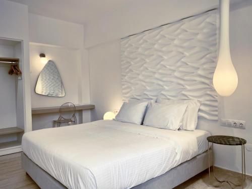 
a white bed with white pillows and pillows at IONIAN SUITES by Bruskos in Agios Georgios
