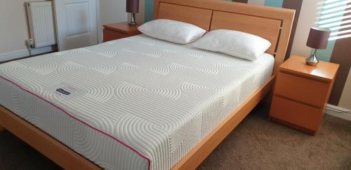 a bed with two pillows on it in a bedroom at Nairnia in Nairn