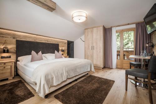 a bedroom with a large white bed and a table at Gästehaus die geislerin in Gerlos