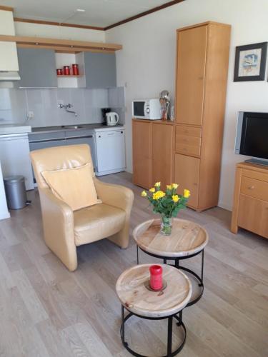 a living room with a chair and a table with flowers at Duinweg 35 in Westkapelle