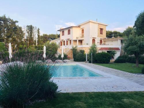 a villa with a swimming pool in front of a house at Tenuta Cardinale in Manduria