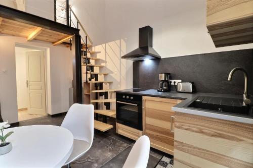 une petite cuisine avec une table blanche et un escalier dans l'établissement L'Appart Magnifique 40m2 idéalement situé au coeur des Remparts, à Avignon