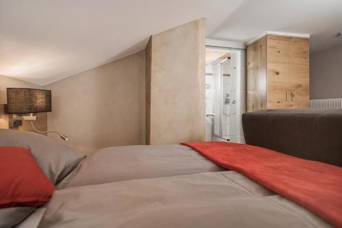 a bedroom with two beds and a red blanket at Gästehaus die geislerin in Gerlos